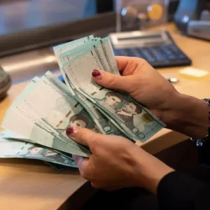 A Bank Teller Counting Dominican Pesos